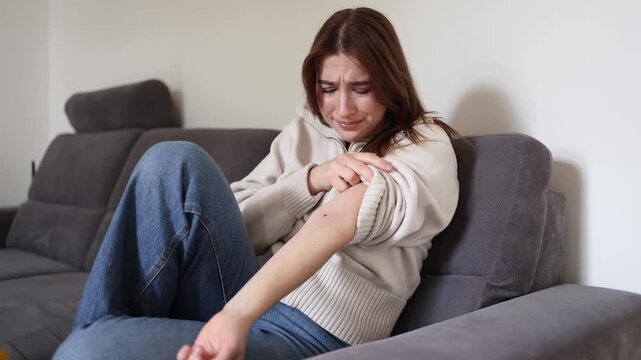 Young woman terrified after discovering tick bite on arm while worrying about Lyme disease infection and dangerous long term health complications at home