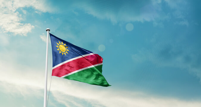 Namibia national flag fluttering. The flag blowing in beautiful soft sky. Namibia national flag for independence day.