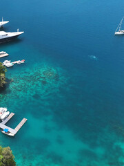 Obraz premium Aerial View of Luxury Yachts and Boats in Clear Palau Waters