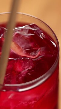 Healthy, berry flavored sparkling kombucha mixing with paper straw, top view. Iced fizzy drinks, and summer vibes.