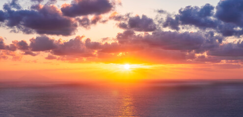 Obraz premium beautiful sunrise or sunset seascape with amazing calm sea water with waves and colorful amazing cloudy morning sky on background