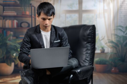 Focused Young Man Working on Laptop in Cozy Indoor Environment