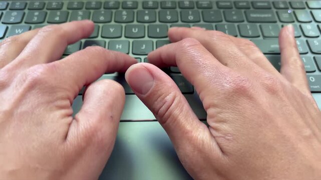 Top-down view of a woman's hands typing on a modern laptop keyboard. Writing, coding, or working on a computer