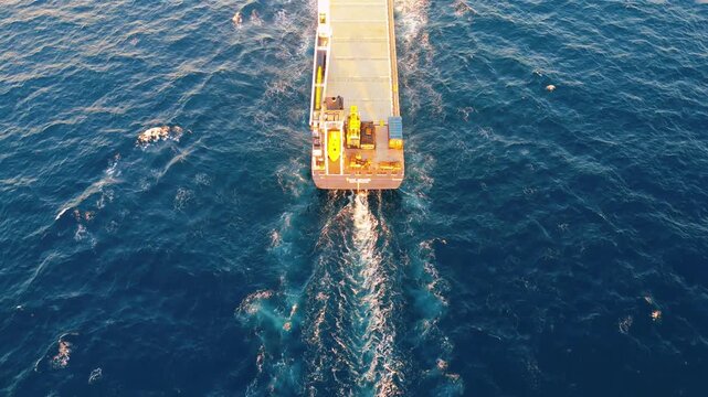 Cinematic aerial footage capturing a flyover from the stern to the bow during sunrise.