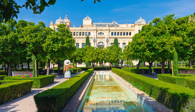 Woman tourist walking in beautiful Pedro Luis Alonso gardens of malaga city hall in Spain