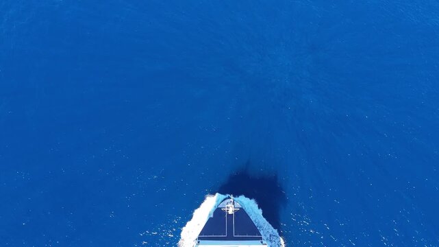 A static top-down aerial perspective of a cargo ship on the water.