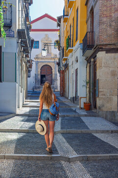 Woman tourist walking up narrow cobblestone street of Granada old town , tour tourism in Spain