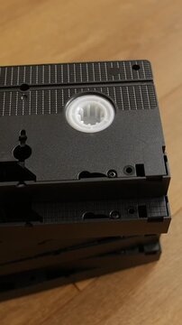 Vintage VHS cassette tapes stacked on wooden surface