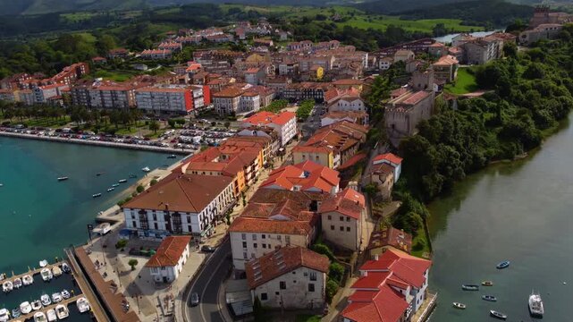 Aerial view of San Vicente de la Barquera old town, featuring the medieval King's Castle, Santa Maria church and traditional architecture in Cantabria, Northern Spain. High quality 4k footage