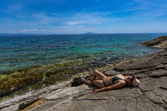 Blonde Woman Sunbathing on Empty &Scaron;i&scaron;an Beach Near Ližnjan, Croatia
