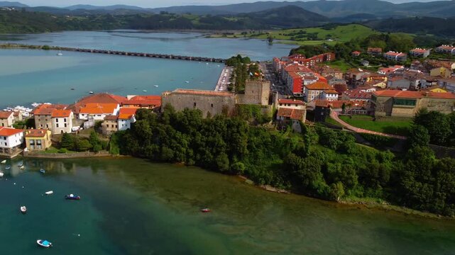 Aerial view of San Vicente de la Barquera old town, featuring the medieval King's Castle, Santa Maria church and traditional architecture in Cantabria, Northern Spain. High quality 4k footage