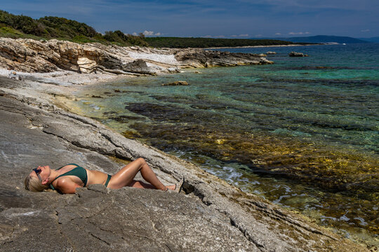 Blonde Woman Sunbathing on Empty &Scaron;i&scaron;an Beach Near Ližnjan, Croatia