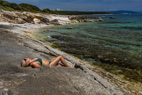 Blonde Woman Sunbathing on Empty &Scaron;i&scaron;an Beach Near Ližnjan, Croatia