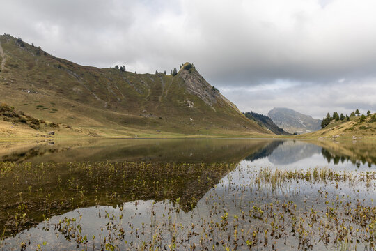 Mirror reflection on Lake Roy with cloudy sky in the Chablais massif, Haute-Savoie, French Alps