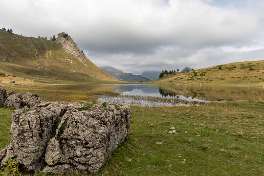 Mirror reflection on Lake Roy with cloudy sky in the Chablais massif, Haute-Savoie, French Alps