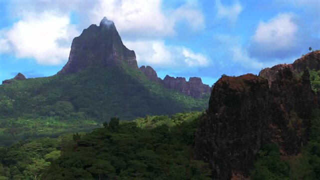 Moorea's dramatic volcanic tall jagged peaks rugged terrain Mount Rotui Mt Toheia Moorea French Polynesia aerial drone Belvedere Lookout CooksOpunohu Bay sunny morning blue sky clouds circle right