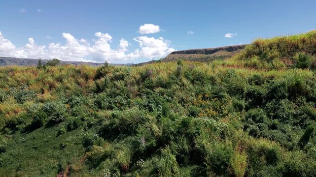 Drone forward flyover revealing terraced open pit mine and exposed geological layers near Bras&iacute;lia, Federal District, Brazil, surrounded by Cerrado vegetation and mineral extraction infrastructure