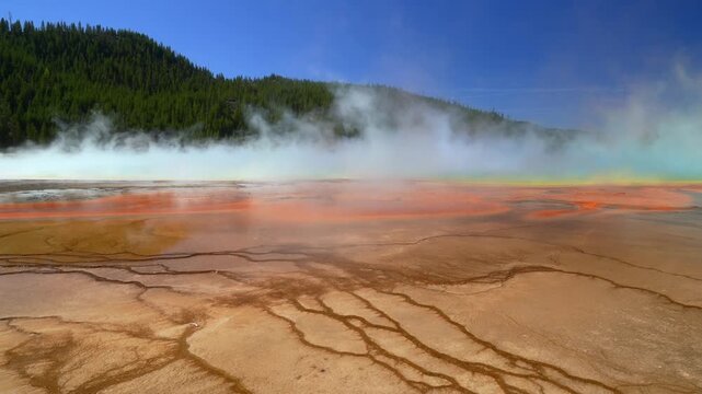 Vibrant turquoise hot springs pool layers Grand Prismatic Spring earth Yellowstone National Park Wyoming sunny morning blue sky thermal steam Boardwalk trail Midway Geyser Basin nature landscape