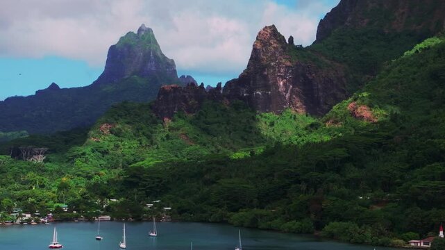 Cooks Bay Opunohu Bay sailboats yachts Mount Rotui Mt Toheia Moorea French Polynesia aerial drone harbor view Belvedere Lookout jagged peaks rugged terrain tall volcanic peaks lush jungle upwards