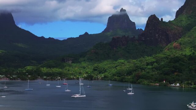Cooks Bay Opunohu Bay sailboats yachts Mount Rotui Mt Toheia Moorea French Polynesia aerial drone harbor view Belvedere Lookout tall volcanic jagged peaks rugged terrain lush jungle upward motion