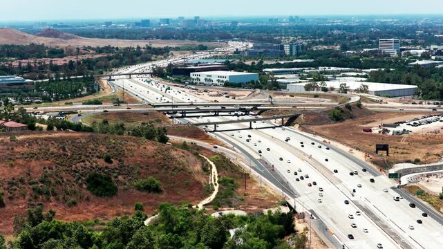 Aerial view of 405 freeway traffic and overpass in Irvine California captured with smooth cinematic drone footage