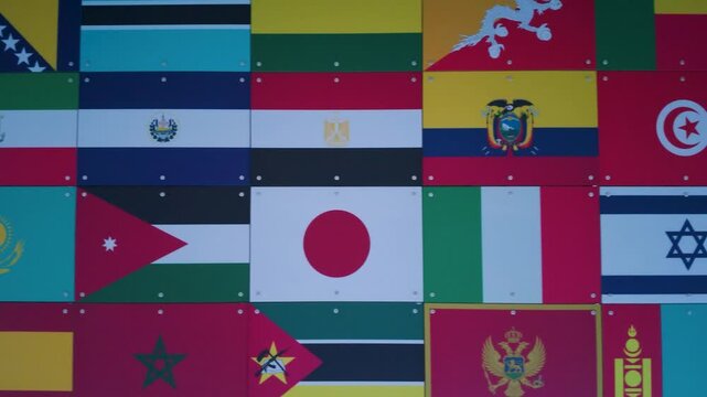 World flags wall panning left across a grid of international banners and national symbols, ideal for globalization, diplomacy, multicultural education, and travel concepts.