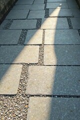 Obraz premium Sunlit Pathway A Serene Stone Walkway with Gravel Accents and Intricate Design