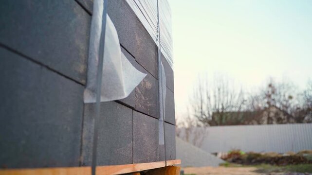 Stacked grey concrete blocks on pallet at construction site close-up