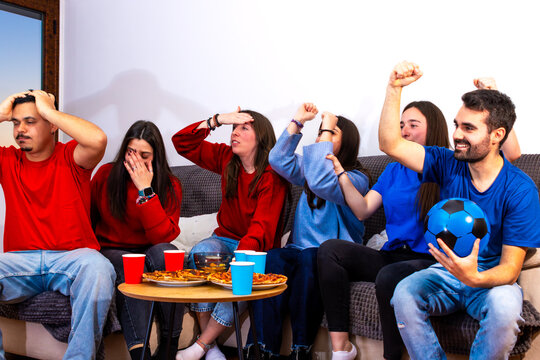 Friends watching international soccer tournament with mixed feelings at home