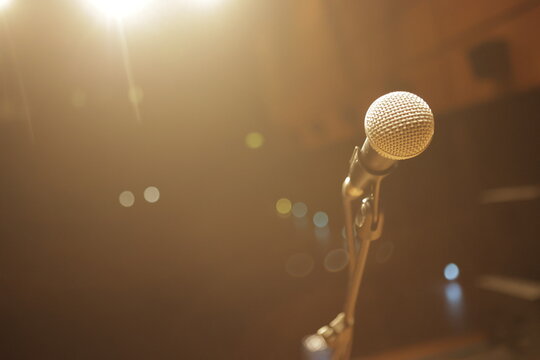 Microphone waiting for singer on stage under warm light