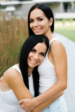 Happy Twin Sisters Hugging Close Up Portrait