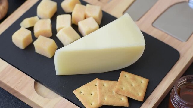 Aged cheese in a triangular block with jam, figs, and nuts. Aged cheese as a food background for your design