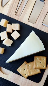 Aged cheese in a triangular block with jam, figs, and nuts. Aged cheese as a food background for your design