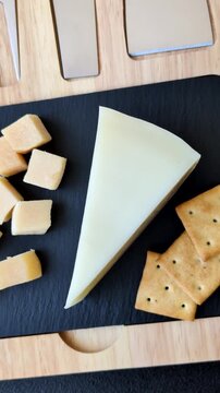 Aged cheese in a triangular block with jam, figs, and nuts. Aged cheese as a food background for your design
