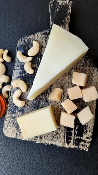 Aged cheese in a triangular block with jam, figs, and nuts. Aged cheese as a food background for your design