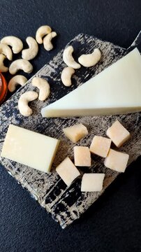 Aged cheese in a triangular block with jam, figs, and nuts. Aged cheese as a food background for your design