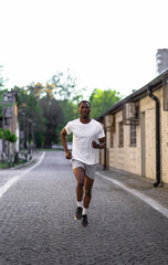 Obraz premium Young Black man running through an urban street.