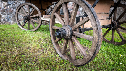 Obraz premium Historic Wooden Wagon Wheels on Traditional Horse Drawn Cart