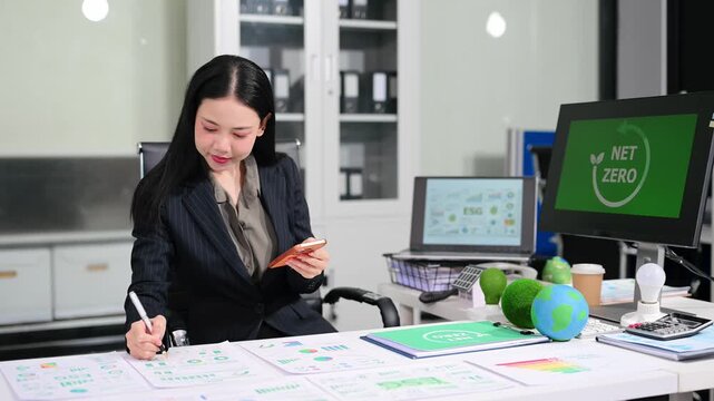 businesswoman reviewing ESG data and Net Zero reports in a modern office, highlighting sustainability, green business, renewable energy and corporate responsibility.