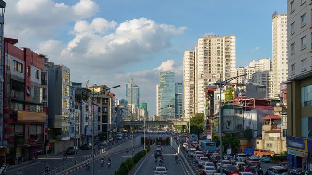 Daytime view of the Le Van Luong underpass in Hanoi with busy traffic, high-rise buildings, and a modern urban streetscape.