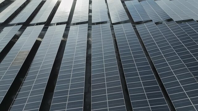 Top-down aerial perspective of solar panel arrays covering a rooftop to support renewable electricity production.