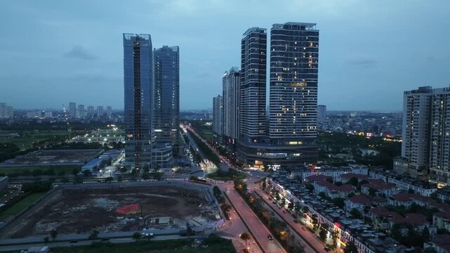 Twilight aerial view of Hoang Minh Thao Street in Hanoi featuring high-rise apartments, commercial buildings, and expanding urban development.