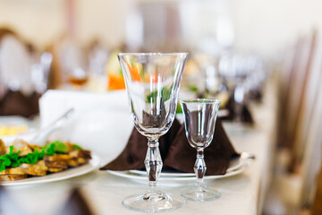 Fototapeta premium Formal wedding banquet table with crystal wine glasses and elegant place settings