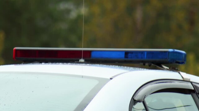 Detail of police vehicle roof-mounted light bar, displaying vibrant red and blue beacon lights, essential equipment for emergency services and maintaining order