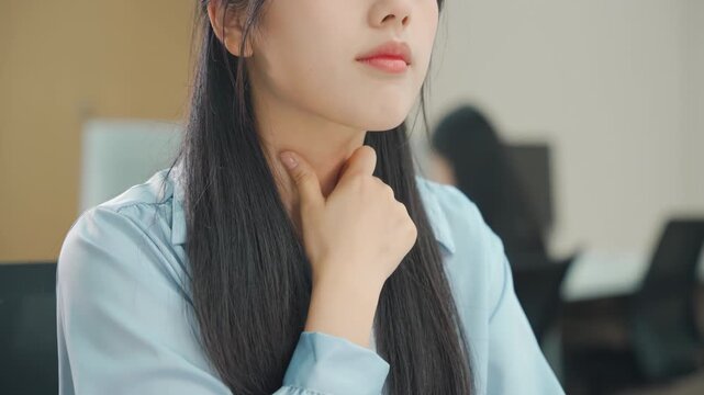 Stressed overwhelmed businesswoman sick and coughing in office, female feeling sick and touching her neck while working late at night in office, prevention of virus spread and cold symptoms concept