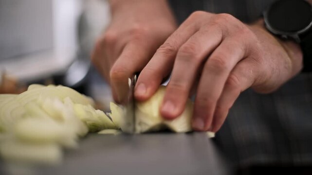 Close-Up View Of A Male Cook Slicing An Onion With A Sharp Knife