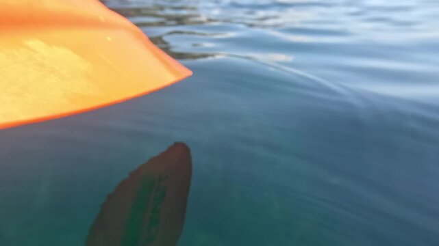 Kayaking water adventure orange kayak bow gliding through calm turquoise sea water during a peaceful summer day