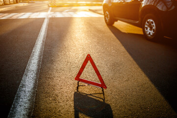 The road triangle stands on the road. amid a broken car © Vlad