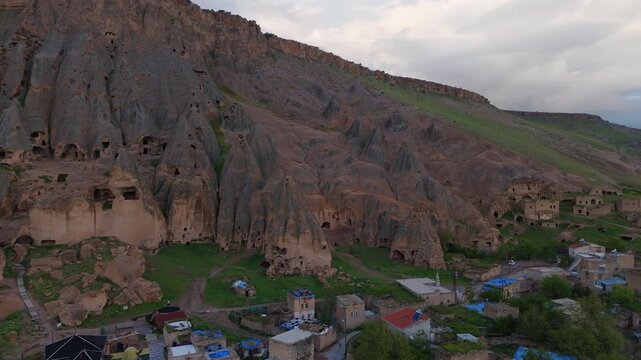 aerial drone shot approaching the ancient troglodyte complex of Selime Cathedral monastery. Unique rock-cut cultural heritage site nestled in a mountain valley in Turkey