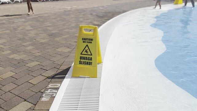 Wet floor sign by swimming pool